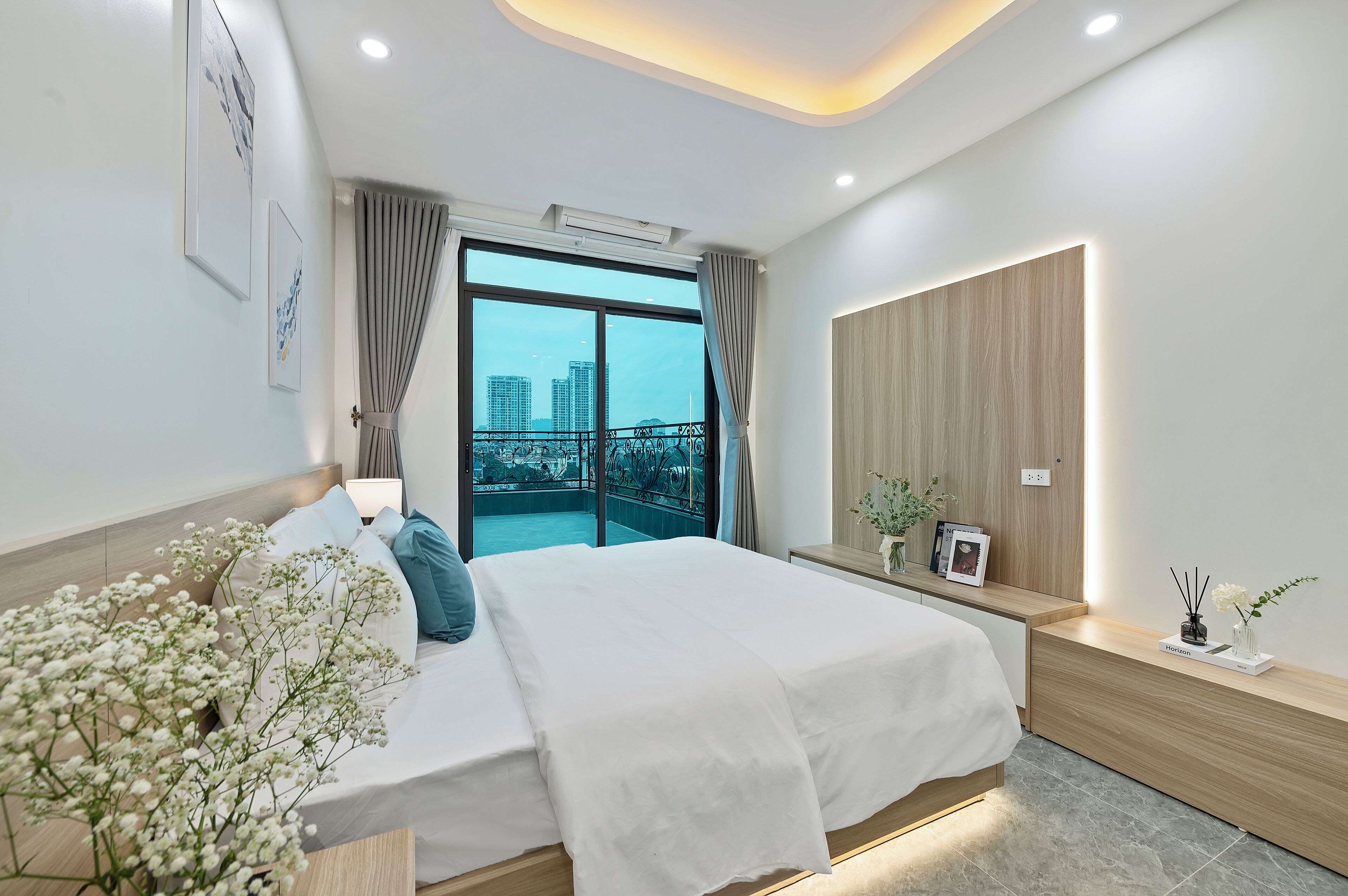 Une chambre moderne avec un grand lit, une vue sur la ville et un balcon.