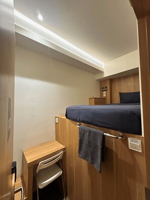 A compact room with a bunk bed, a desk, and a chair. - ALTHIA PRIVATE CAPSULE QUARTERS (Legian)