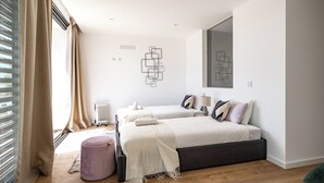 A modern bedroom with two beds, a radiator, a large mirror, and a minimalist wall art piece.