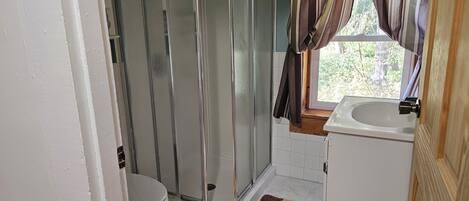 Un baño con inodoro, ducha y lavamanos.
