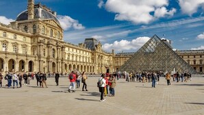A large open square with the Louvre Museum and the iconic glass pyramid in the center.