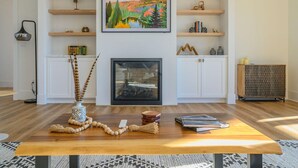 Una sala de estar con chimenea, estanterías de madera y un cuadro enmarcado.