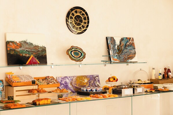A buffet with various food items and decorative art pieces on display. - Hotel Rosabianca (Rimini)