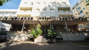 A hotel entrance with a name sign, steps leading up to the door, and potted plants. - Hotel Rosabianca (Rimini)