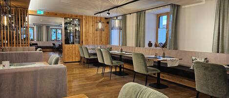 A modern restaurant interior with wooden accents, a bar area, and a seating arrangement.