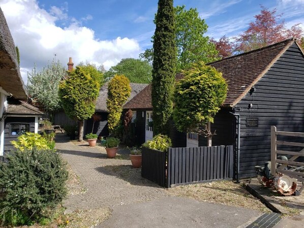 A courtyard with a gravel path, wooden fences, and potted plants. - AbingPlough House (Abingdon)