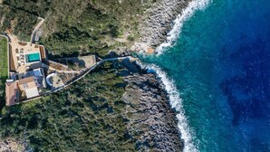 An aerial view of a coastal property with a swimming pool, a patio area, and a rocky shoreline. - Evilia Beach Villa With Private Pool (Zakynthos)