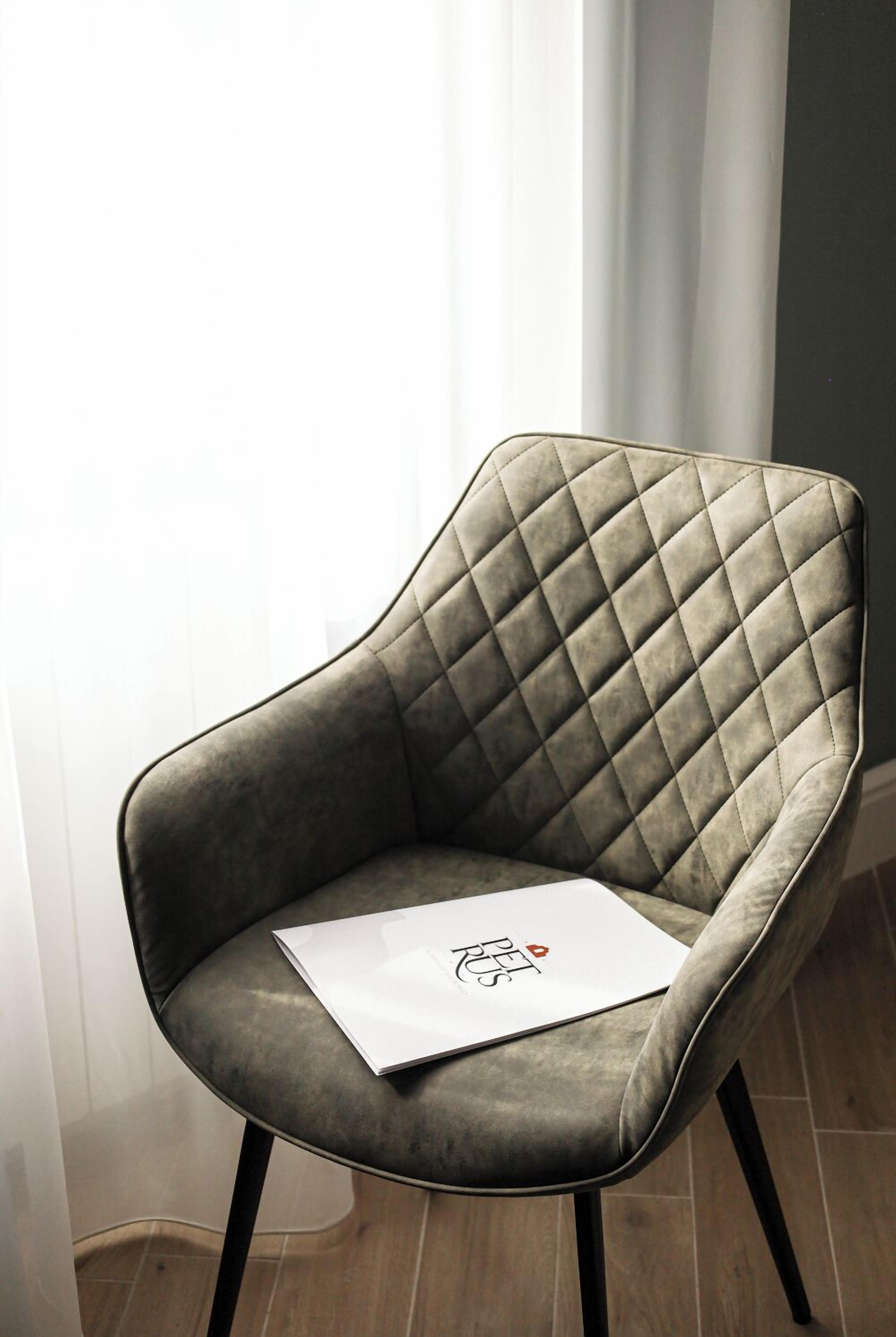 Una silla con respaldo acolchado y una señal blanca con un logotipo.
