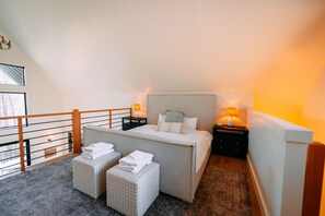 A bedroom with a bed, two bedside tables, a window, and a balcony. - Stonehaven | Hocking Hills, Modern, Views, Hot Tub (Rockbridge)