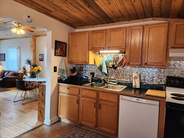 A kitchen with wooden cabinets, a dishwasher, and a stove. - Charming Historic Bungalow (Montrose)