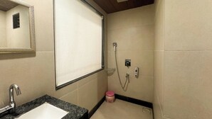 Une salle de bain avec un lavabo, un miroir, une douche et des murs carrelés.