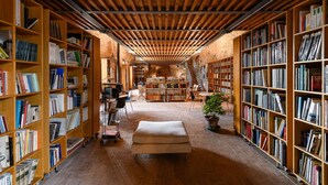 A spacious library with wooden bookshelves and a central seating area.