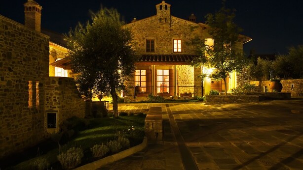 A stone building with multiple windows and a central entrance, surrounded by a paved courtyard and greenery. - Villa in Casa Biondo with 23 bedrooms sleeps 46 (Casa Biondo)