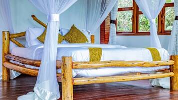 A bed with a canopy, wooden frame, and white bedding with yellow accents.