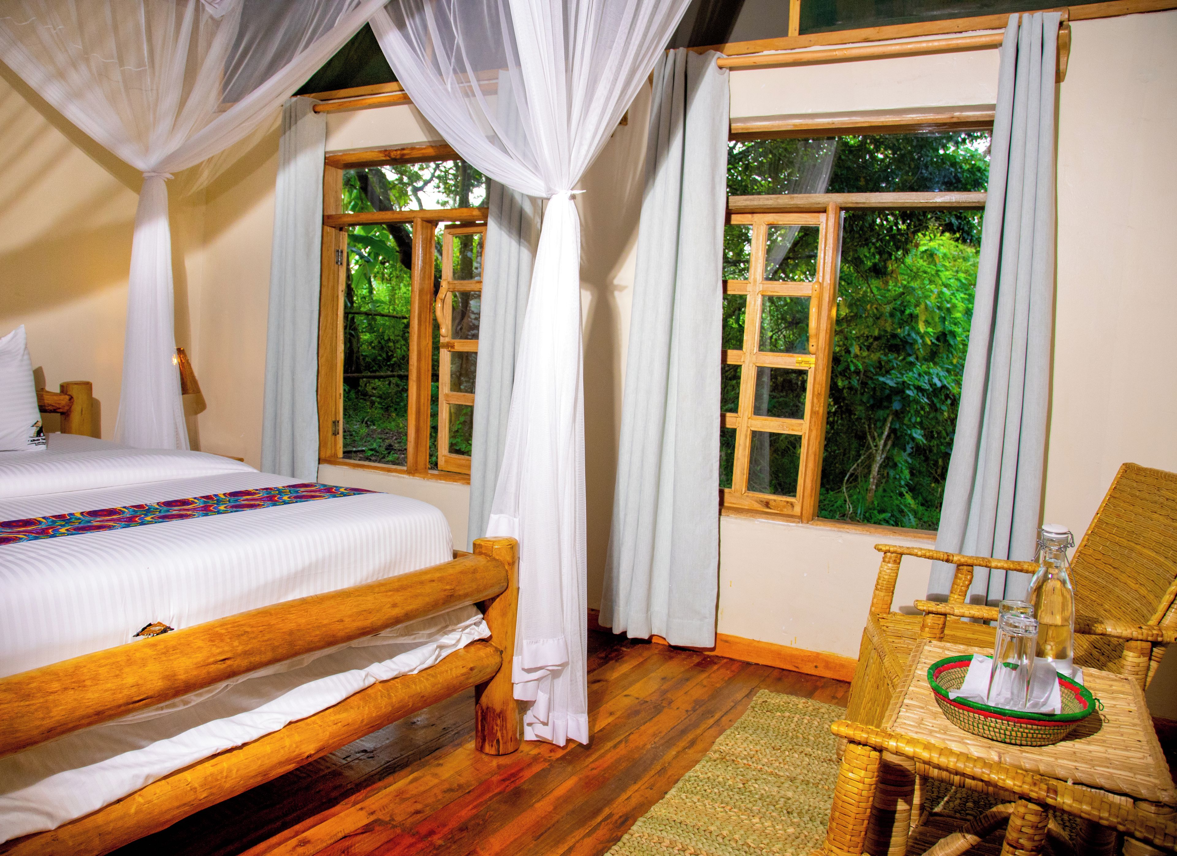 A bedroom with a wooden bed, a wicker chair, and a window with curtains.
