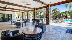 An outdoor patio area with seating, a pool, and a view of palm trees. - Luxurious Solterra Home w/ Pool, Spa & Themed Rooms Near Attractions (Davenport)
