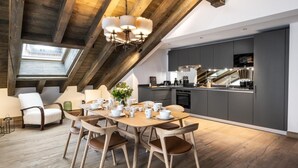 Una moderna stanza in stile loft con zona pranzo, angolo cottura e finestra a lucernario.