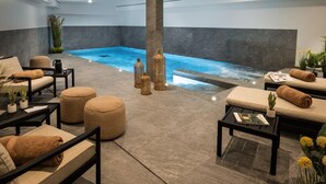 Un área de spa con un jacuzzi, asientos y elementos decorativos.