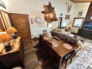 A dining area with a wooden table, chairs, and a central seating arrangement.