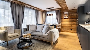 En moderne stue med sofa, sofabord og spiseplads med et bord dækket til to personer.