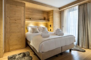 Ein Schlafzimmer mit Holzwänden, einem Bett, Kissen und Handtüchern.