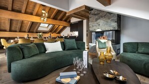 A modern living room with a green sofa, a wooden coffee table, and a fireplace. - Wifi, 150m from ski slopes, 2nd floor, sauna, hammam, balcony, fireplace or stove, tv, 74m², Méribel (Méribel - Les Allues)