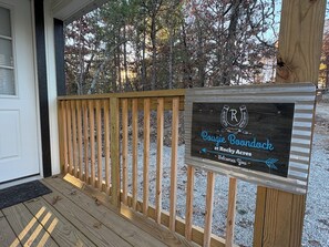 Une terrasse en bois avec une enseigne indiquant « Boujie Boondock à Rocky Acres », accueillant les visiteurs.