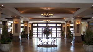 A spacious lobby with a central chandelier, large potted plants, and a grand entrance with double doors. - Penthouse Luxury. WOW! Panoramic views of everything! BradAndJoeyRentals (Nuevo Vallarta)