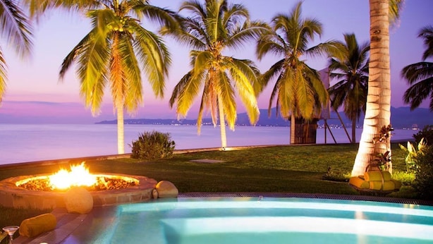 A pool area with a fire pit, palm trees, and a view of the ocean. - Penthouse Luxury. WOW! Panoramic views of everything! BradAndJoeyRentals (Nuevo Vallarta)