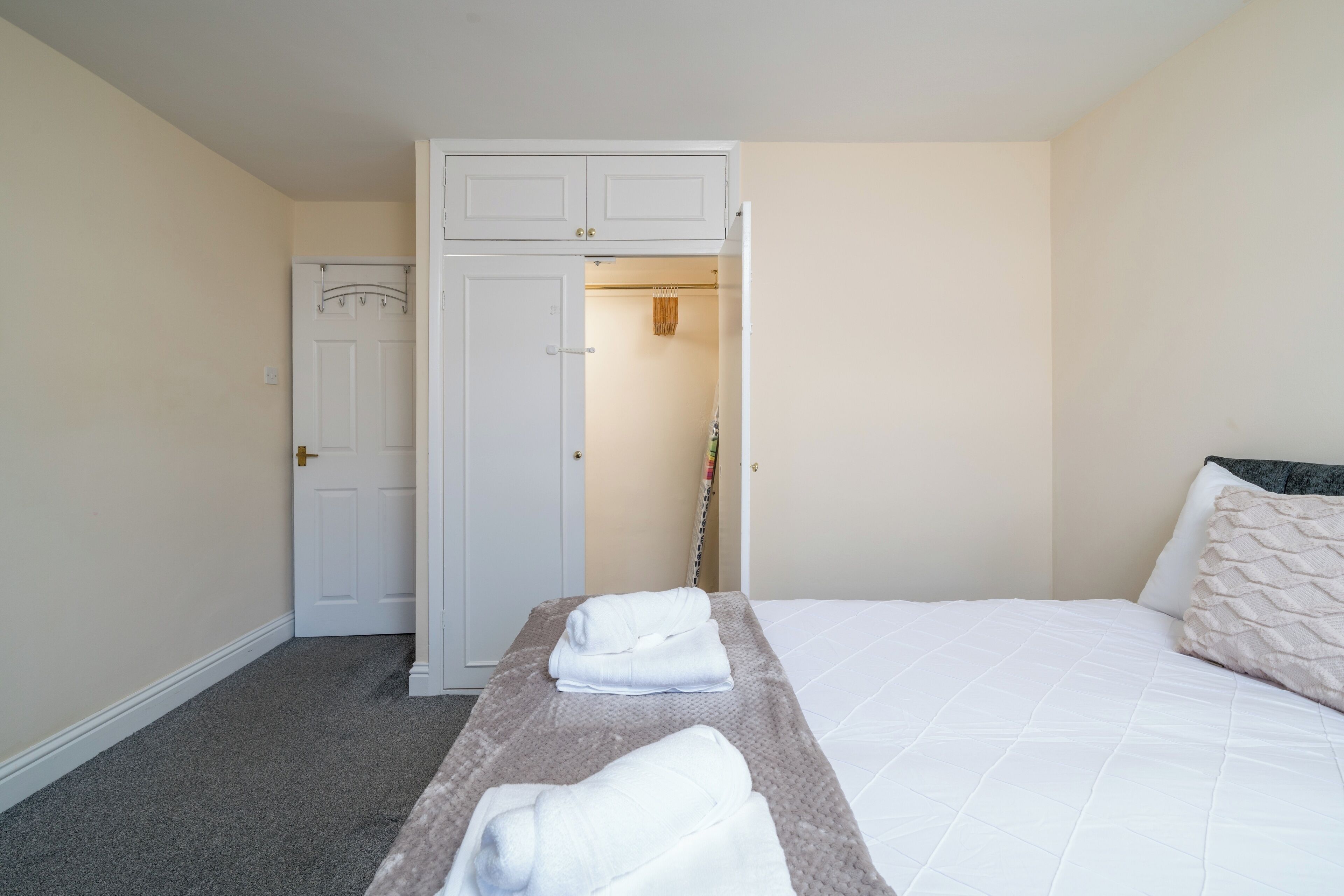 Une chambre d’hôtel avec un lit, une armoire et une porte.