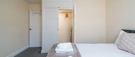 Una habitación de hotel con cama, armario y puerta.