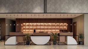 A modern reception area with a wooden panel wall, a reception desk, and a patterned floor. - Ramada Encore By Wyndham Bhiwadi Phool Bagh Chowk (Tijara)