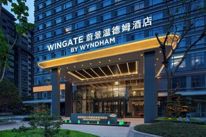 A hotel entrance with a modern design, featuring a prominent sign and a covered entrance area. - Wingate By Wyndham Zhuhai Gongbei Port (Zhuhai)
