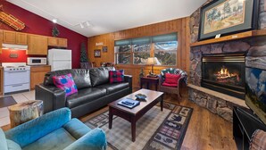 A cozy living room with a fireplace, a sofa, a coffee table, and a television.