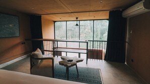 Une pièce moderne dotée d’une grande fenêtre, d’un ventilateur de plafond, d’un banc en bois et d’une petite table.