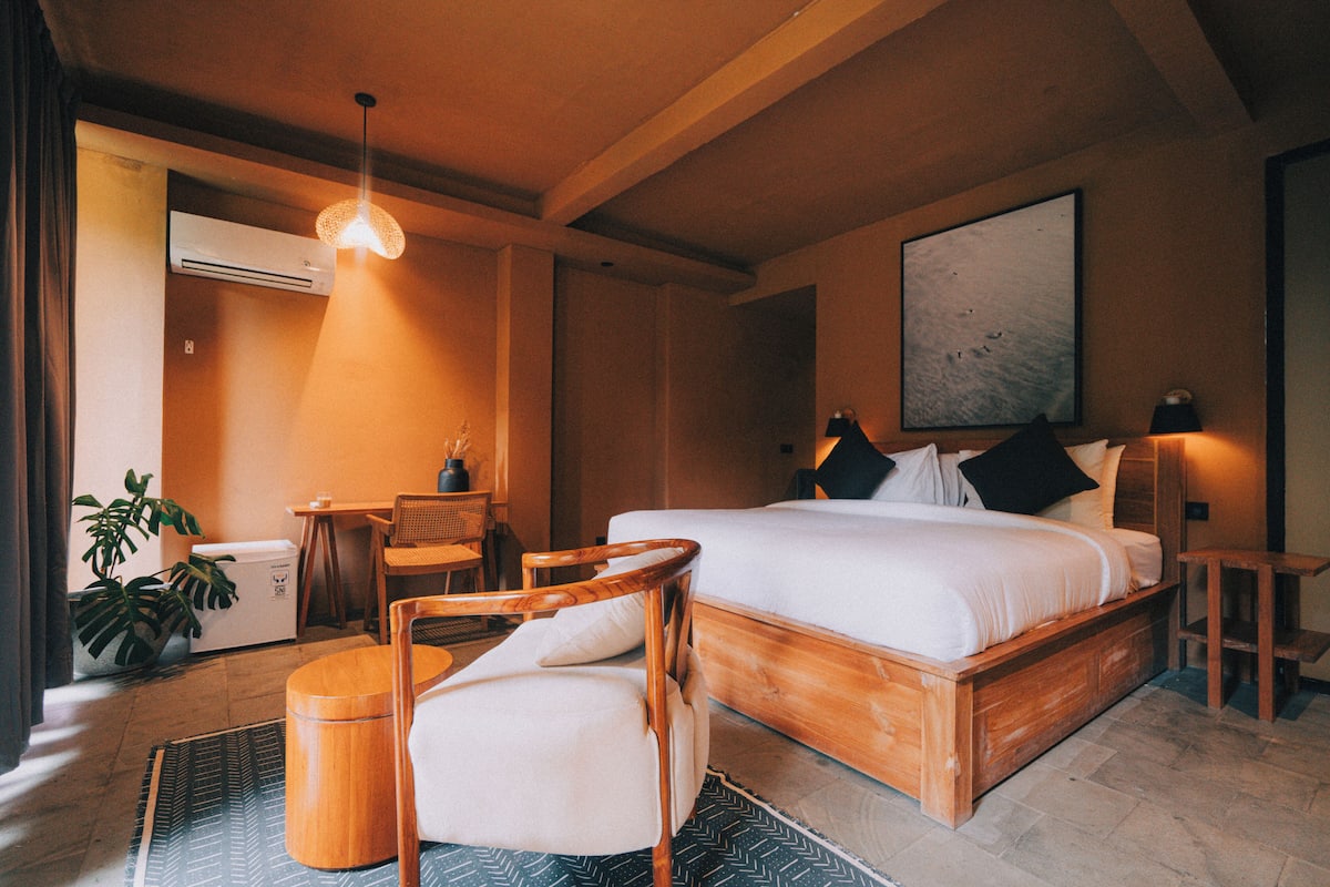 A modern bedroom with a wooden bed, a desk, and a chair.