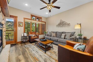 A spacious living room with a sofa, coffee table, and a fireplace.