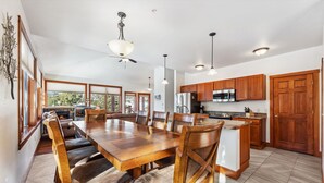 A spacious kitchen with wooden cabinets, a large island, and a dining area with a long table and chairs.
