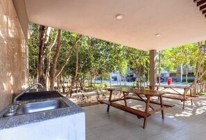 Enjoy a shaded outdoor space with a sink and picnic table surrounded by trees.