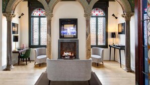 Un salón espacioso con chimenea, dos sillones y un televisor.
