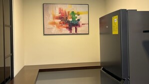 A kitchen with a black refrigerator, a painting on the wall, and a skylight above. - Fully furnished two-bedroom apartment (Cuenca)