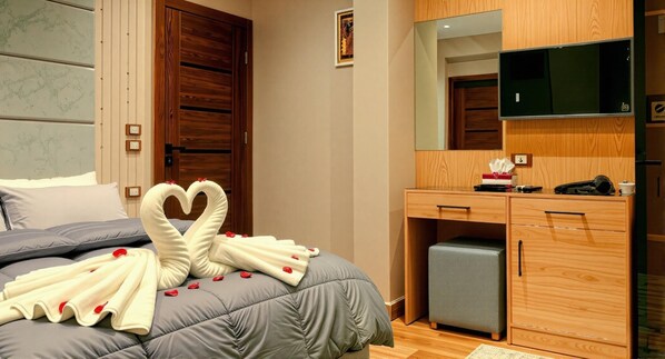 Una habitación de hotel con una cama, un armario de madera, un escritorio y un televisor.