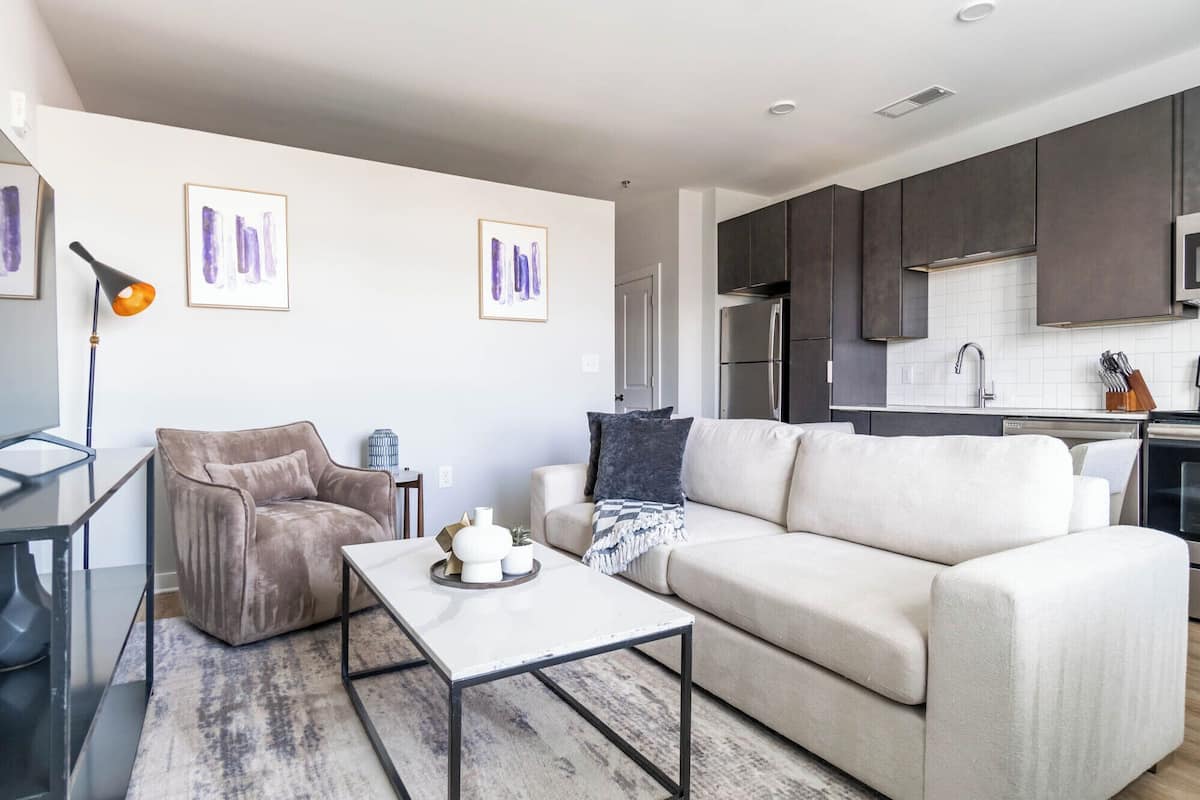 A modern living room with a sofa, coffee table, and artwork on the wall.