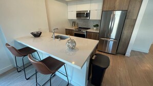Uma cozinha moderna com ilha central, eletrodomésticos de aço inoxidável e design minimalista.