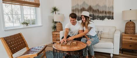 Ein gemütliches Wohnzimmer mit einem Holztisch, einem weißen Sofa und einem Teppich mit Muster.
