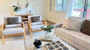 A living room with two armchairs, a sofa, a coffee table with a decorative vase, and a large window with blinds. - Prime Location Yosemite Adventure by Casa Oso (Oakhurst)