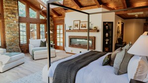 A spacious bedroom with a large bed, a stone wall, and a fireplace. - Stone House I Thoughtful Nature Stay Near Yosemite (Mariposa)