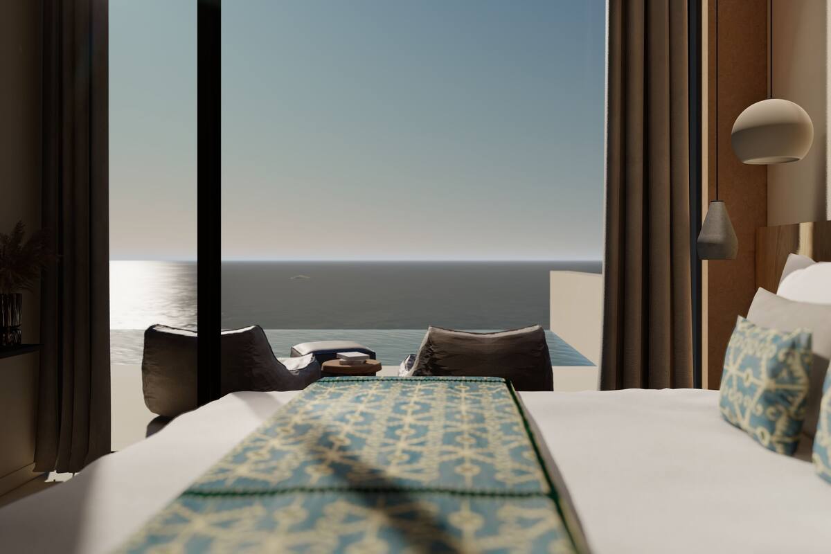 Une chambre d’hôtel avec un grand lit, une vue sur l’océan et une lampe moderne.