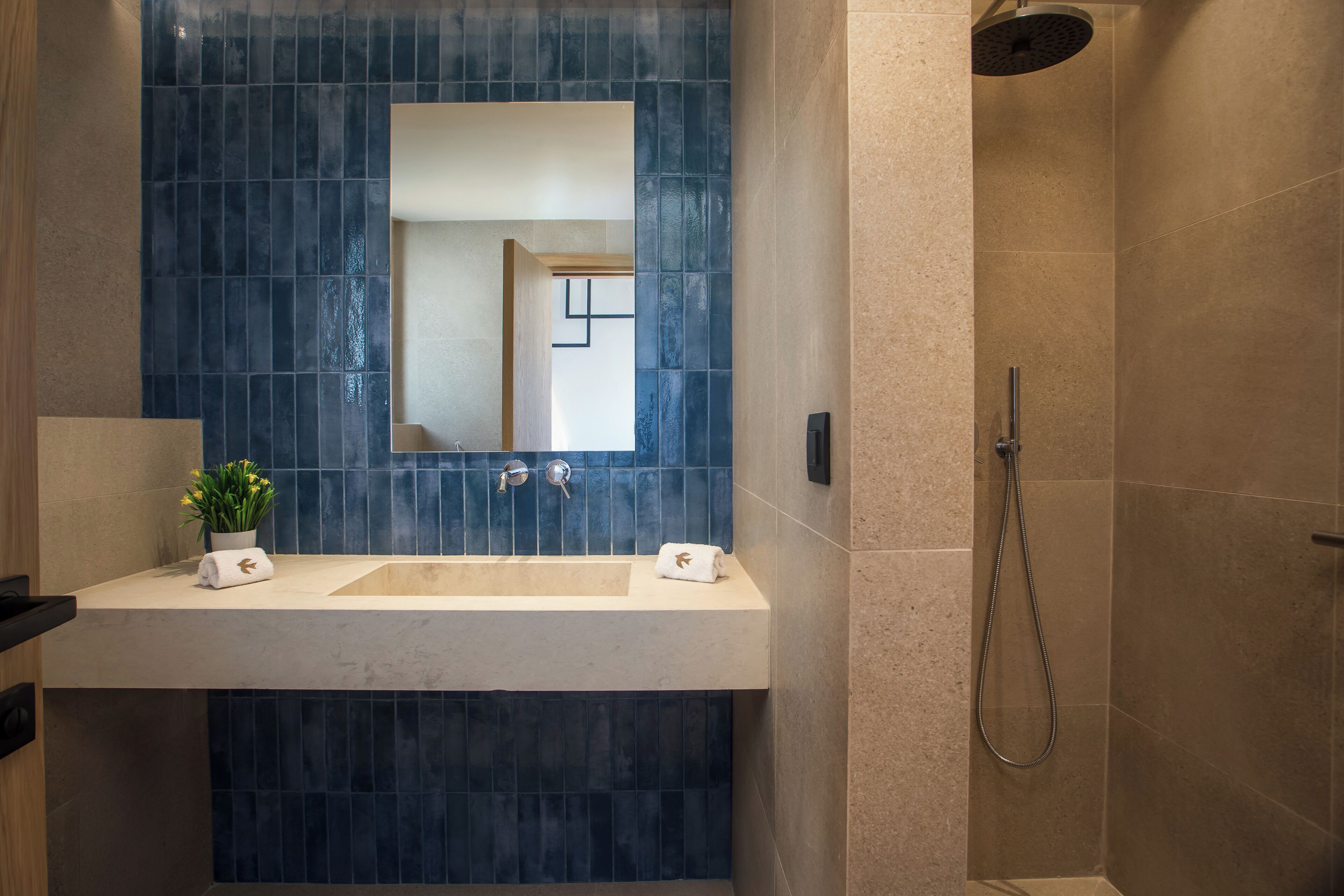 A bathroom with two sinks, a mirror, and a shower.