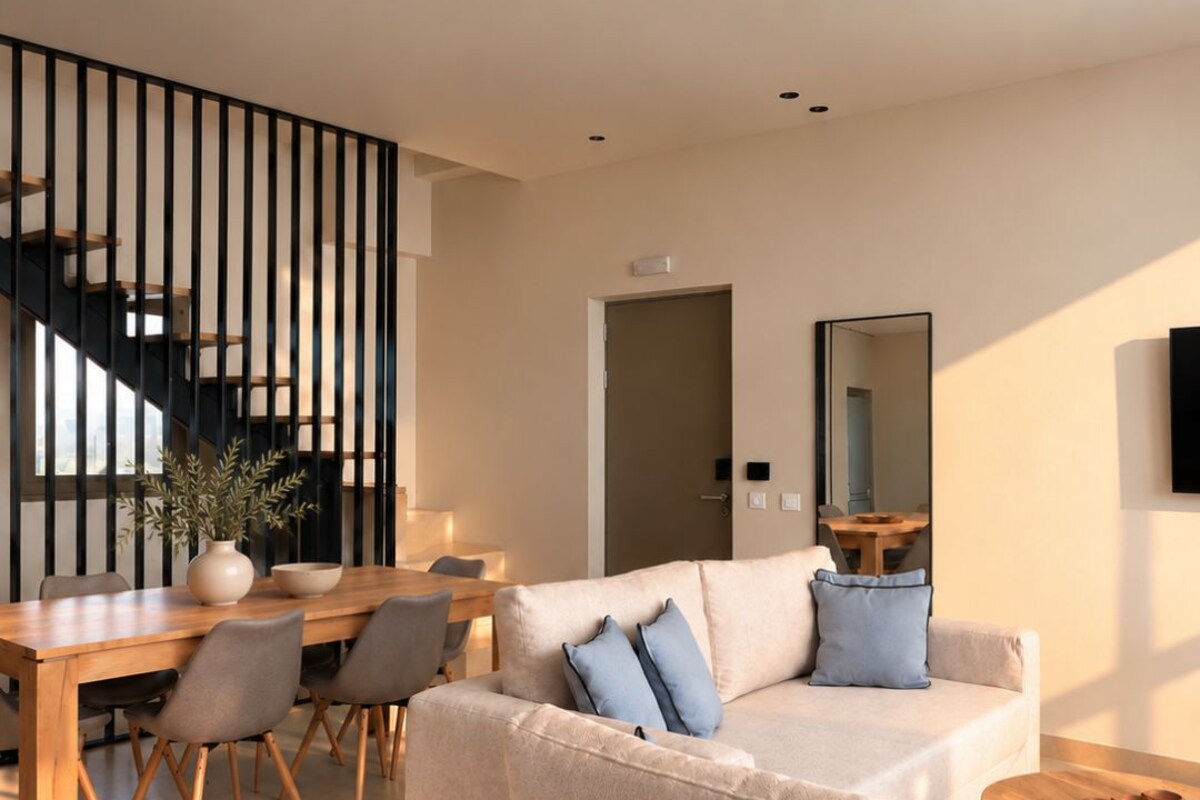 A modern living room with a sofa, coffee table, and dining area.